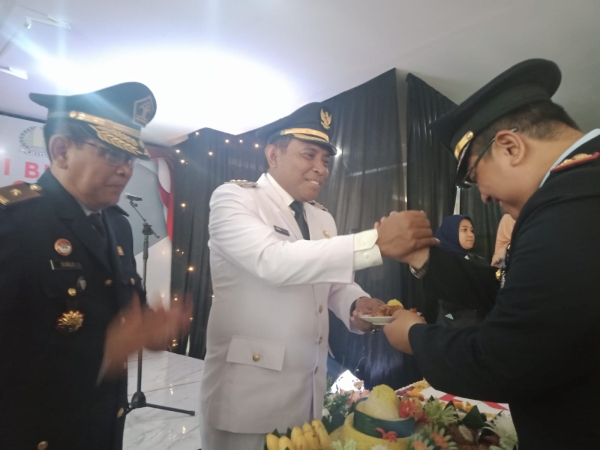 Kepala Kantor imigrasi Kelas II non TPI Baubau, Teguh Santoso saat menyerahkan tumpeng kepada Wali Kota Baubau, La Ode Ahmad Monianse saat acara HBI ke-73