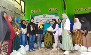 Kordinator Presidium Forhati Sultra, Rahmawati Azi saat menyerahkan paket sembako kepada salah satu warga